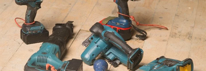 Sechs Elektrowerkzeuge auf Holzboden